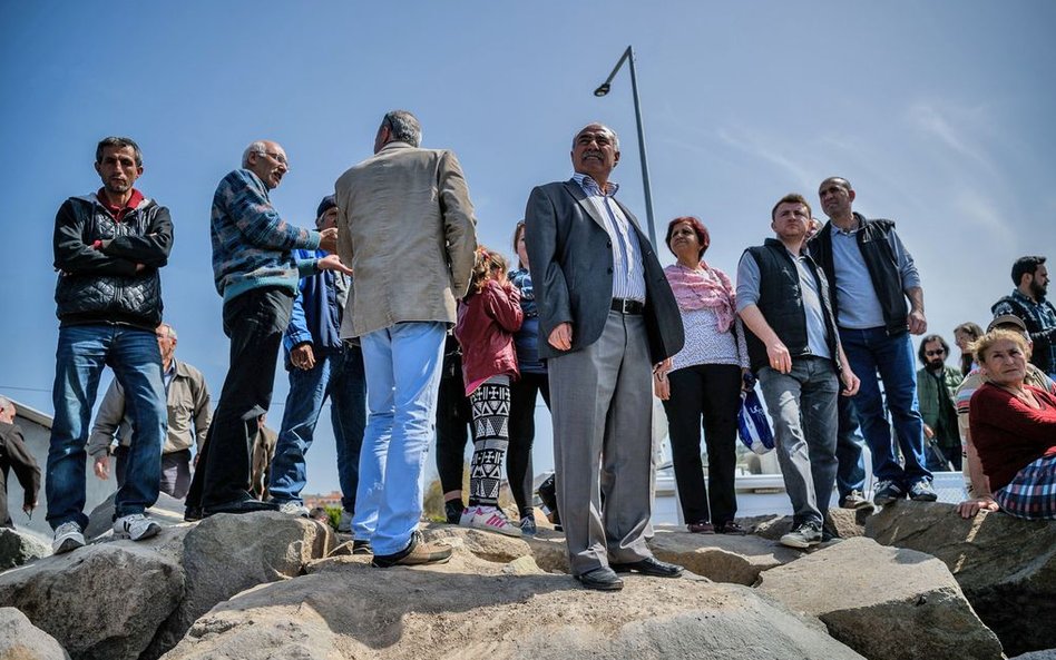 Mieszkańcy Dikili przyglądają się imigrantom wysiadającym po przybiciu do portu