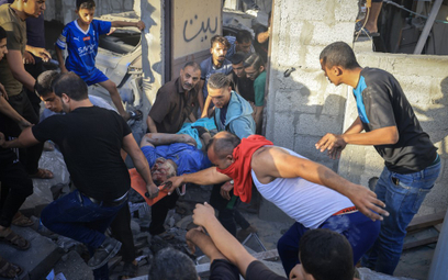 Palestyńczycy ewakuują rannego mężczyznę po izraelskim ataku w Chan Junis w południowej Strefie Gazy