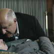 Ławrentij Beria (Simon Russell Beale) pochyla się nad martwym wodzem (Gary Oldman) – scena z filmu.