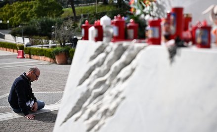 Mężczyzna modli się przed pomnikiem Jana Pawła II przed kliniką Gemelli, gdzie leczony jest papież F