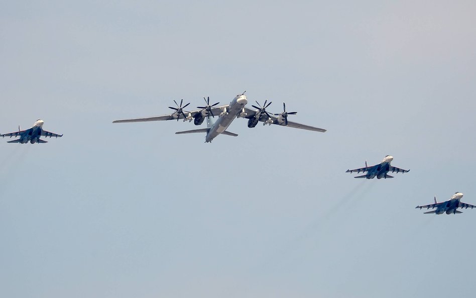 Rosyjski bombowiec strategiczny Tupolew Tu-95 z eskortą w czasie parady wojskowej w Moskwie