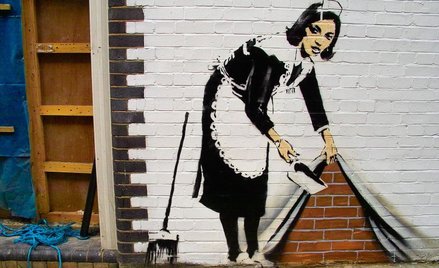 „Sweep It under the Carpet” - praca Banksy'ego z 2006 roku na budynku w północnym Londynie.
