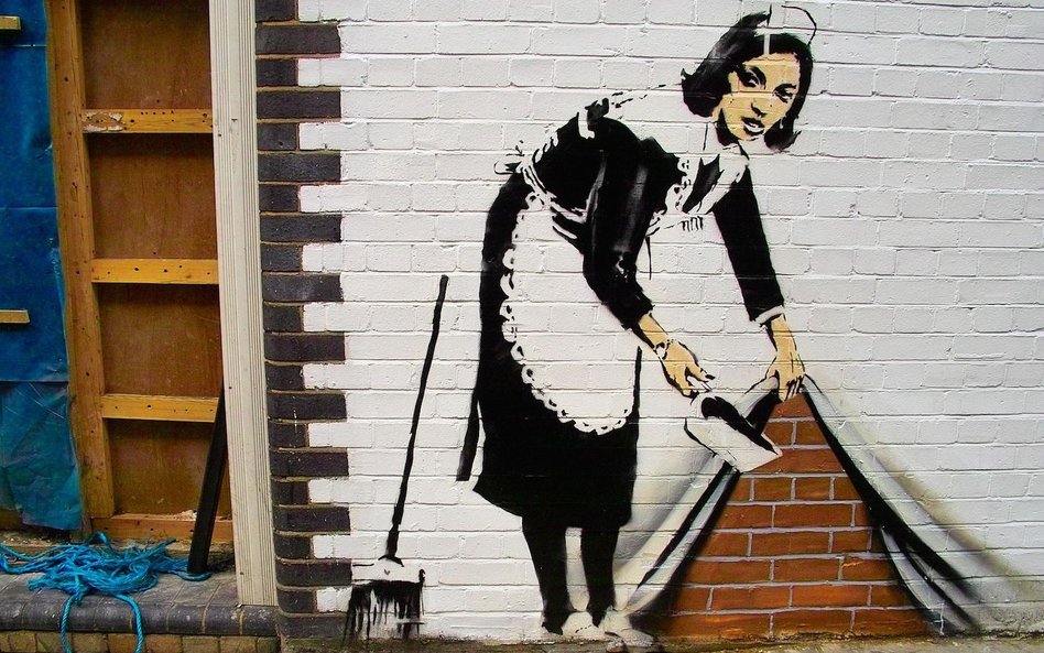 „Sweep It under the Carpet” - praca Banksy'ego z 2006 roku na budynku w północnym Londynie.