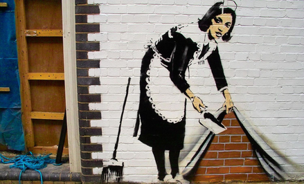 „Sweep It under the Carpet” - praca Banksy'ego z 2006 roku na budynku w północnym Londynie.