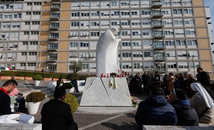 Wierni modlą się o zdrowie papieża przy pomniku Jana Pawła II przed szpitalem klinicznym Gemelli