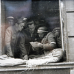 Grupa powstańców z 3. kompanii Batalionu „Kiliński” czytająca prasę w oknie Gimnazjum św. Wojciecha 