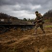 Ukraiński żołnierz obok zniszczonego rosyjskiego transportera piechoty
