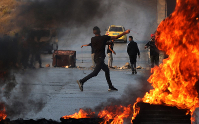 Palestyński uczestnik demonstracji rzuca kamieniami w izraelskich żołnierzy podczas starć w mieście 