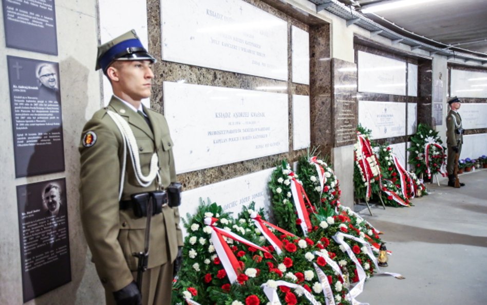 Warta i kwiaty przy grobach ofiar katastrofy smoleńskiej w Świątyni Opatrzności Bożej w Warszawie