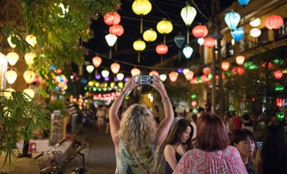 Turystka robi zdjęcie smartfonem na starówce w Hoi An w prowincji Quảng Nam w Wietnamie