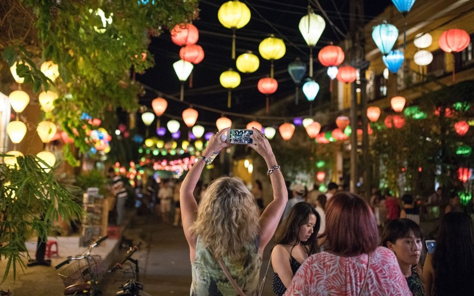 Turystka robi zdjęcie smartfonem na starówce w Hoi An w prowincji Quảng Nam w Wietnamie