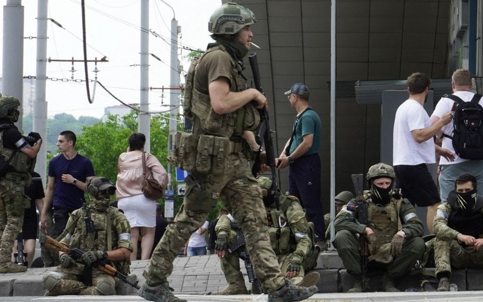 Członkowie grupy Wagnera siedzą na chodniku podczas patrolowania centrum Rostowa nad Donem