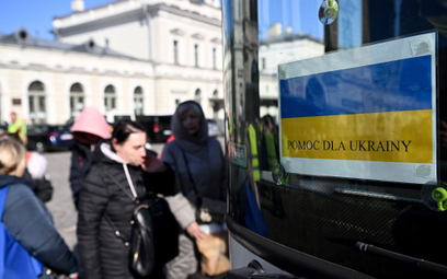 Uchodźcy z Ukrainy wsiadają do autokaru mającego zawieźć ich w głąb Polski przed dworcem PKP w Przem