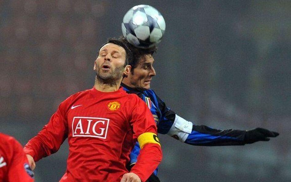Środkowy Manchesteru Ryan Giggs (L) w starciu z Javierem Aldemarem Zanettim z Interu