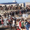 Członkowie Czerwonego Krzyża rozdają żywność migrantom na plaży El Trampolín w Ceucie.