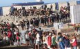Członkowie Czerwonego Krzyża rozdają żywność migrantom na plaży El Trampolín w Ceucie.
