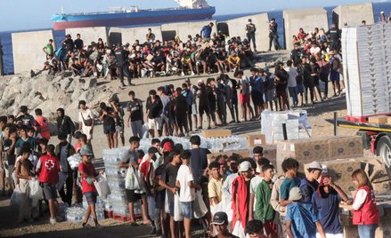 Członkowie Czerwonego Krzyża rozdają żywność migrantom na plaży El Trampolín w Ceucie.