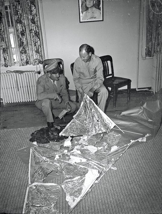 Gen. Roger Ramey (po lewej) i płk Thomas J. DuBose patrzą na szczątki „balonu meteorologicznego”, 7 