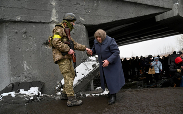 Ukraiński żołnierz pomaga starszej kobiecie