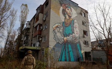Ukraiński żołnierz obok zniszczonego budynku mieszkalnego w Awdijiwce. Zdjęcie z listopada 2023 roku