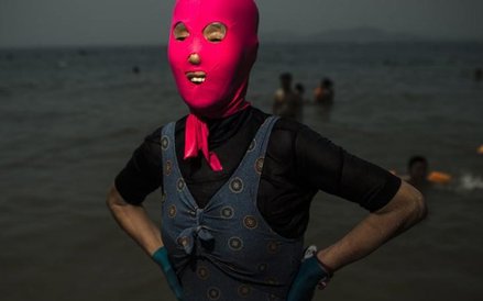 >24 czerwca, Quingdao, Chiny. Kobieta w facekini – specjalnej masce, która ma chronić przed promieni