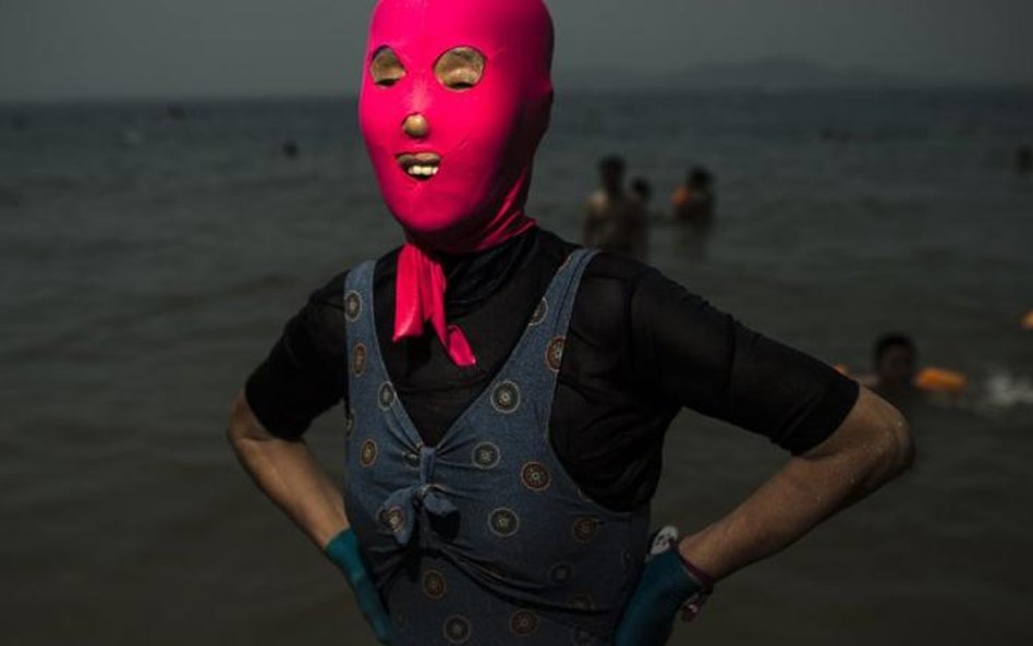 >24 czerwca, Quingdao, Chiny. Kobieta w facekini – specjalnej masce, która ma chronić przed promieni
