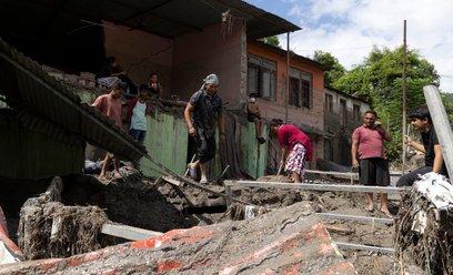 Ludzie sprzątają swój zniszczony dom po powodzi błyskawicznej w dystrykcie Dhading w Nepalu.