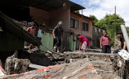 Ludzie sprzątają swój zniszczony dom po powodzi błyskawicznej w dystrykcie Dhading w Nepalu.