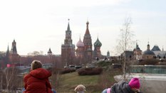 Dzieci cieszą się ciepłym dniem w parku Zariadie z Kremlem i soborem Wasyla Błogosławionego w tle, w