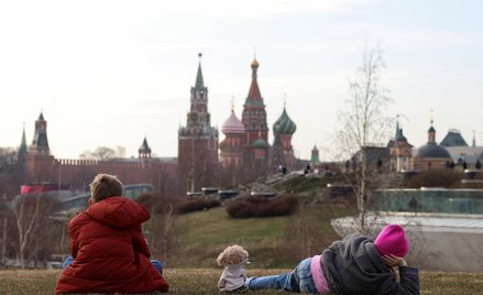 Dzieci cieszą się ciepłym dniem w parku Zariadie z Kremlem i soborem Wasyla Błogosławionego w tle, w