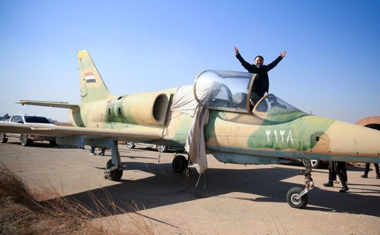Rebeliant w kokpicie samolotu, porzuconego przez syryjskie wojsko na lotnisku Kuweires we wschodniej
