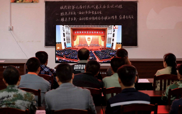 Mieszkańcy wioski na południu Chin oglądają wystąpienie Xi Jinpinga, w którym ogłasza pokonanie bied