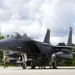 Lotnicy różnych specjalności tankują samolot myśliwsko-bombowy F-15E Strike Eagle, którego pilot cał