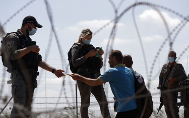 Przedstawiciele izraelskich sił bezpieczeństwa sprawdzają dokumenty Palestyńczyków