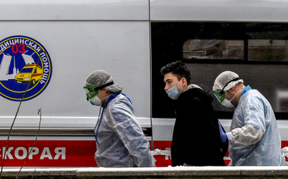 Pracownicy ochrony zdrowia prowadzą chorego na COVID-19 do szpitala