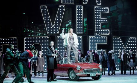 „La Boheme” – scena zbiorowa z II aktu, z napisem w tle