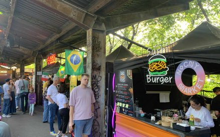 Na pierwszym planie stoisko "Sushi Burger" z charakterystycznym neonem