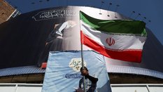 Mężczyzna z irańską flagą na ulicy Teheranu świętuje ogłoszenie, że USA doszły do porozumienia z Ira