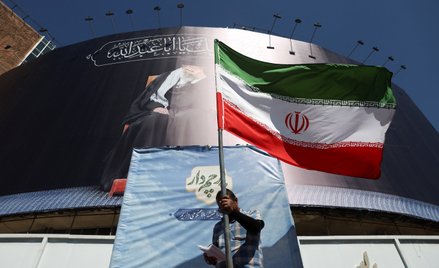 Mężczyzna z irańską flagą na ulicy Teheranu świętuje ogłoszenie, że USA doszły do porozumienia z Ira
