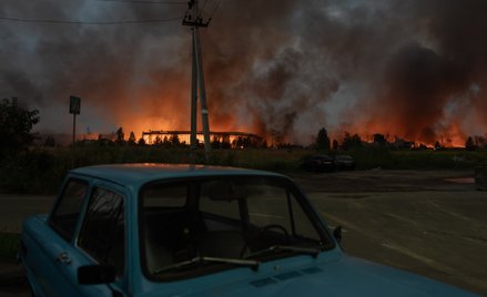 To zdjęcie przedstawia ogień i dym unoszący się z magazynu zniszczonego podczas potężnych rosyjskich