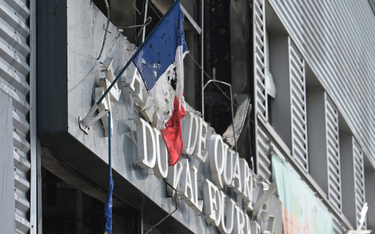 Zniszczona francuska flaga na fasadzie spalonego ratusza w dzielnicy Le Val Fouree w Mantes-la-Jolie