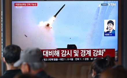 Na dworcu kolejowym w Seulu ludzie oglądają archiwalne nagranie przedstawiające próbę rakietową prze