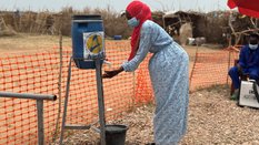 Kobieta myje ręce przy wejściu do ośrodka izolacji dla chorych na cholerę w obozach dla uchodźców w 