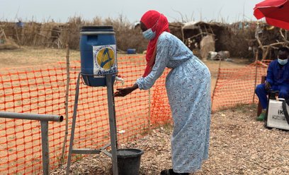 Kobieta myje ręce przy wejściu do ośrodka izolacji dla chorych na cholerę w obozach dla uchodźców w 
