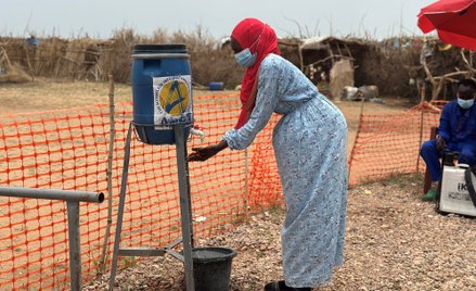 Kobieta myje ręce przy wejściu do ośrodka izolacji dla chorych na cholerę w obozach dla uchodźców w 