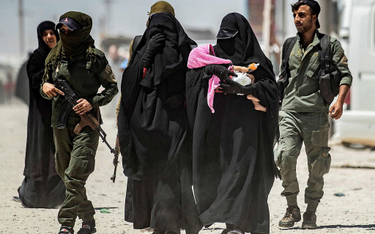 Obóz Al-Hol w północno-wschodniej Syrii. Kurdyjskie strażniczki eskortują żony dżihadystów