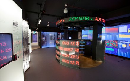 Sala ukazująca sposób funkcjonowania współczesnej giełdy. W centralnym punkcie wyświetlane są aktual