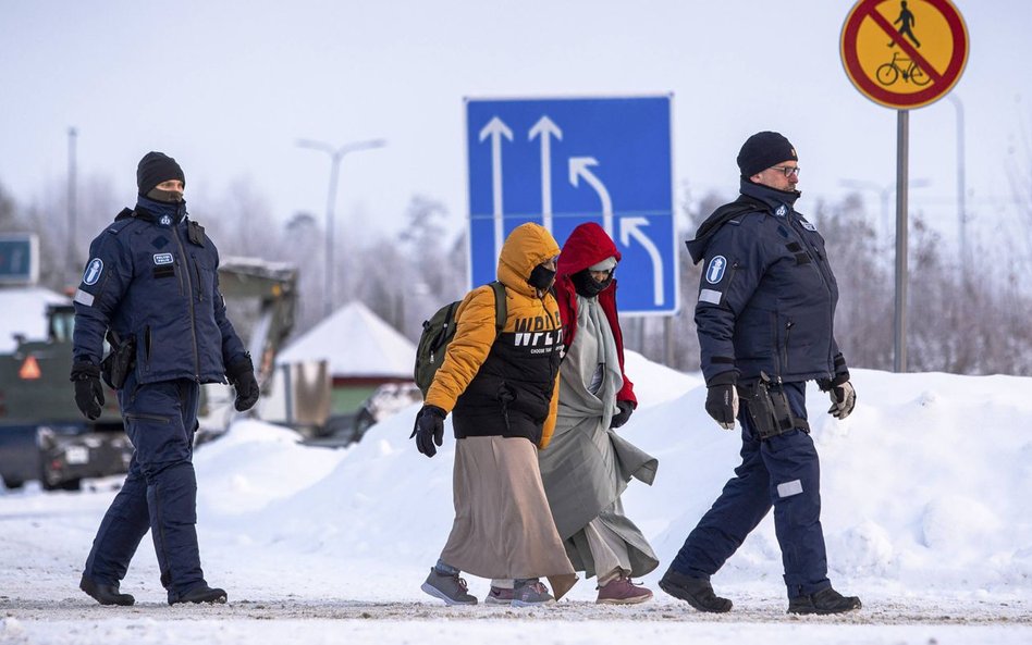 Policja graniczna eskortuje osoby ubiegające się o azyl w Finlandii. Listopad 2023