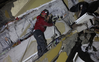 Ratownik szuka ofiar i ocalałych wśród gruzów budynku, który zawalił się w wyniku trzęsienia ziemi w