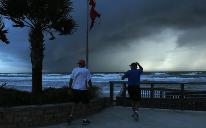 Mężczyźni obserwujący wywołany przez huragan Dorian sztorm z plaży w Ormond na Florydzie